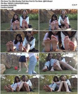 Two Girls Showing Their Bare Feet On The Grass